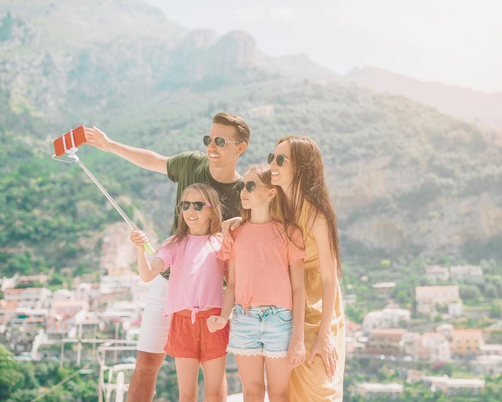 Family with children taking travel photo and video